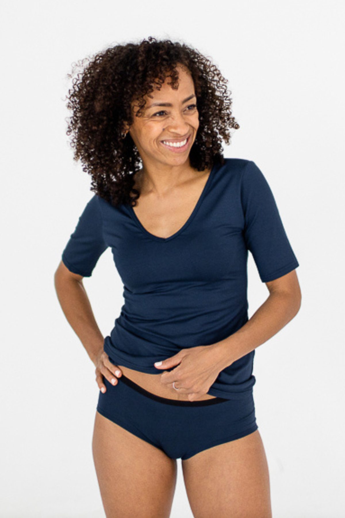 A woman wearing a navy blue low rise boybrief with no cheek peek design, made of bamboo rayon blend fabric.