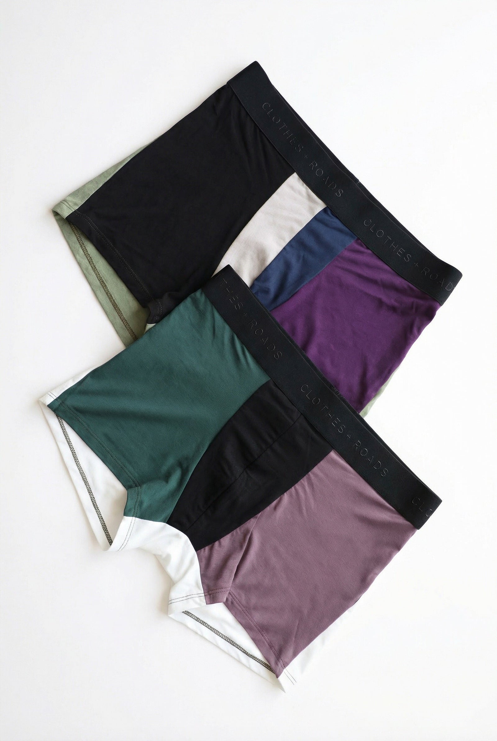 Two pairs of colorful patchwork men’s trunk underwear on a white background