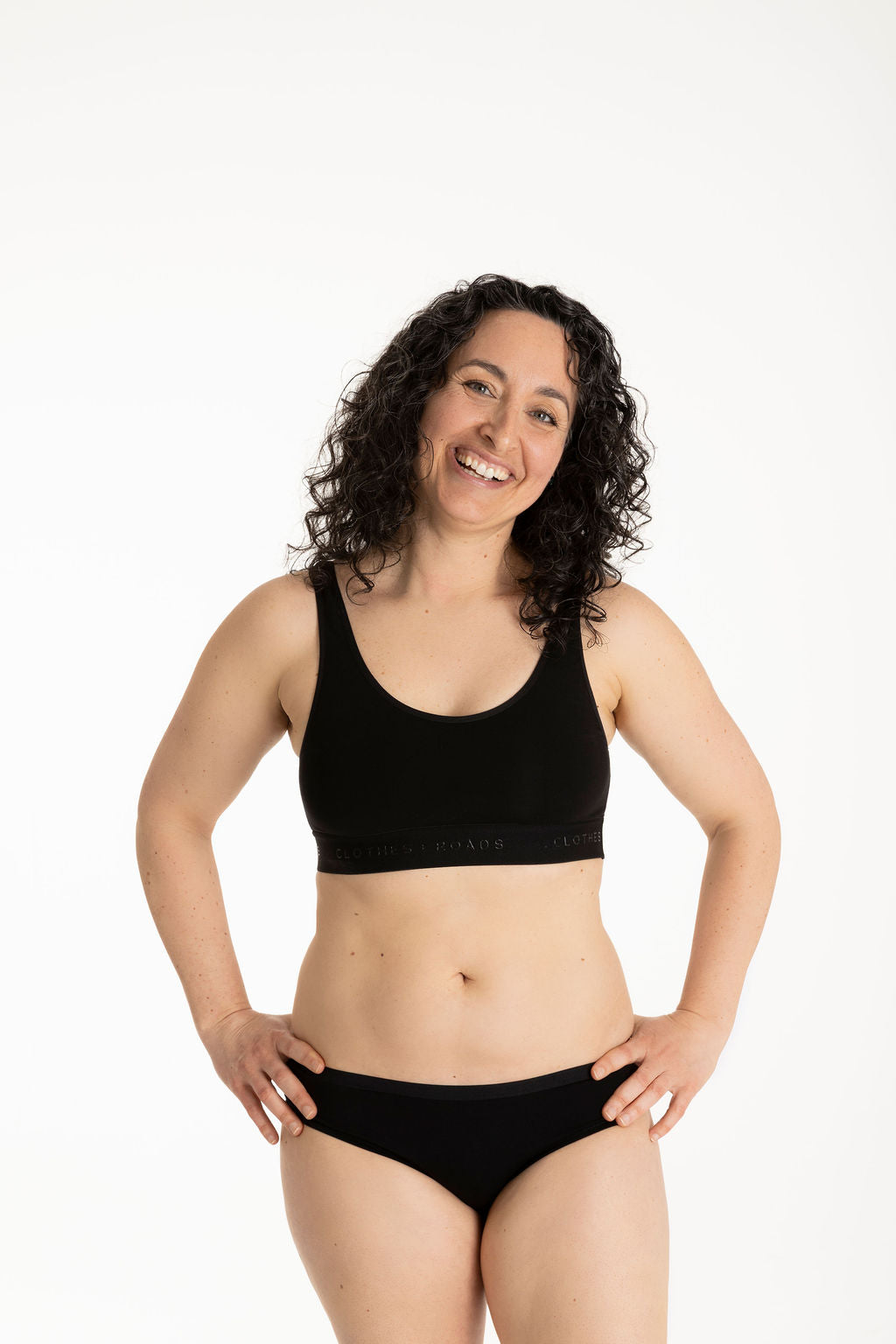 Woman in a wearing a black bralette and bikini underwear