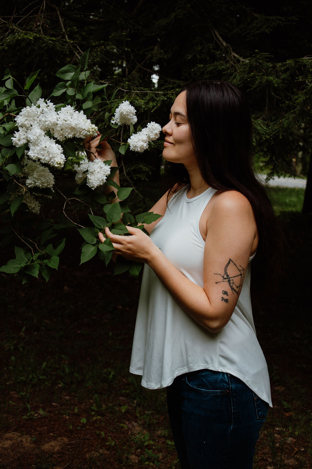 Woman holding white flowers in a natural setting