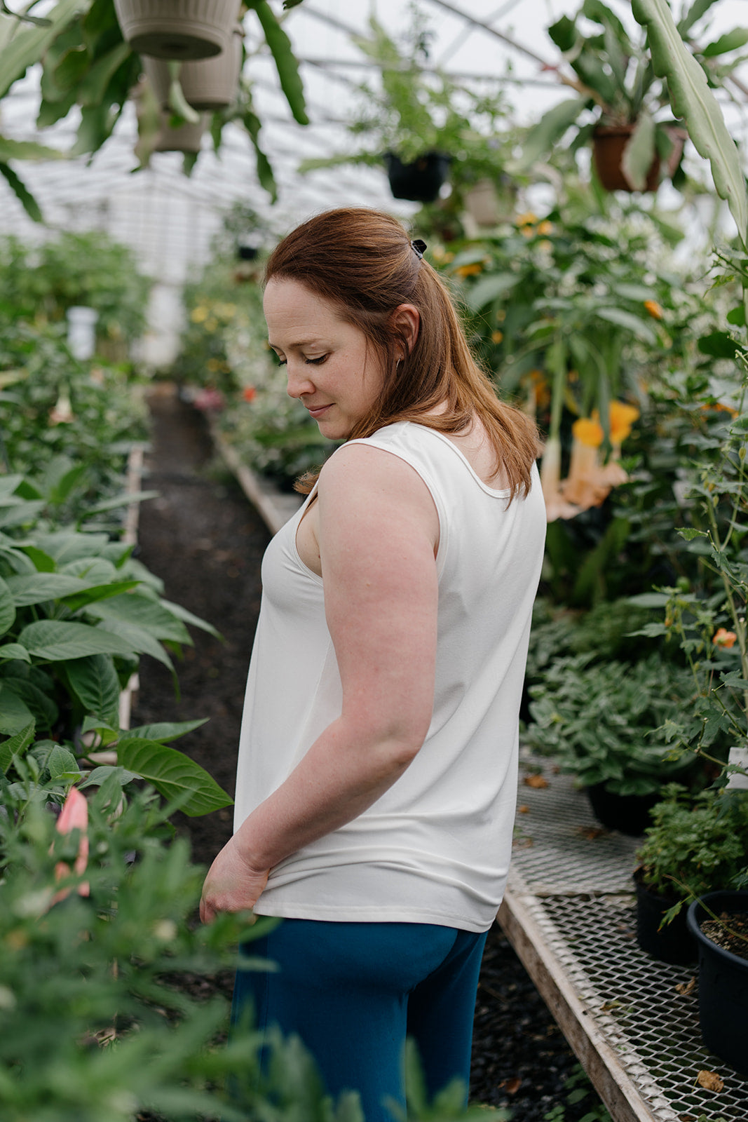 Woman wearing the ivory reversible bamboo camisole, side view.