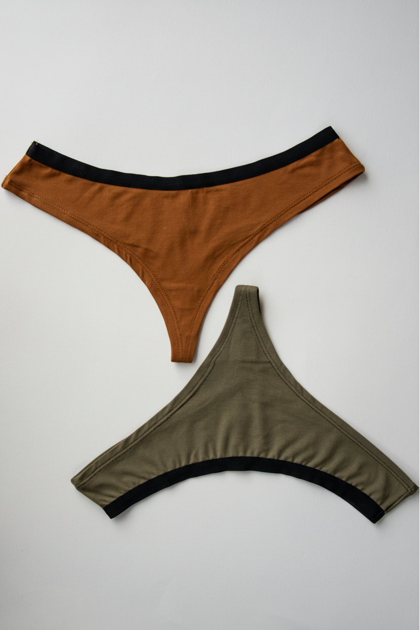 Two pairs of women's underwear, one orange and one olive green, on a light gray background.