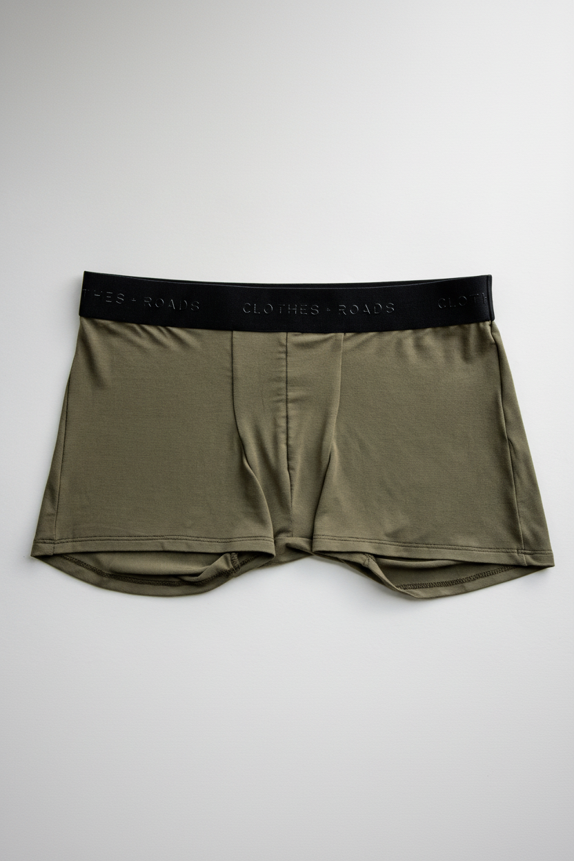 Olive green boxer trunks with black waistband on a white background