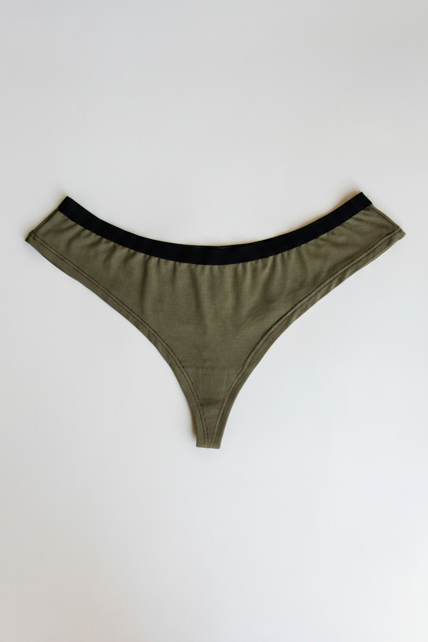Green thong with black waistband on a white background