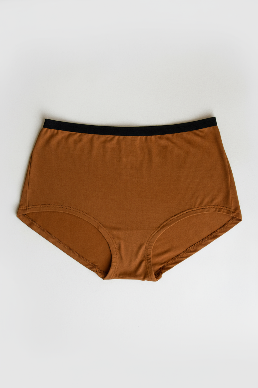 Orange underwear with black waistband on a white background
