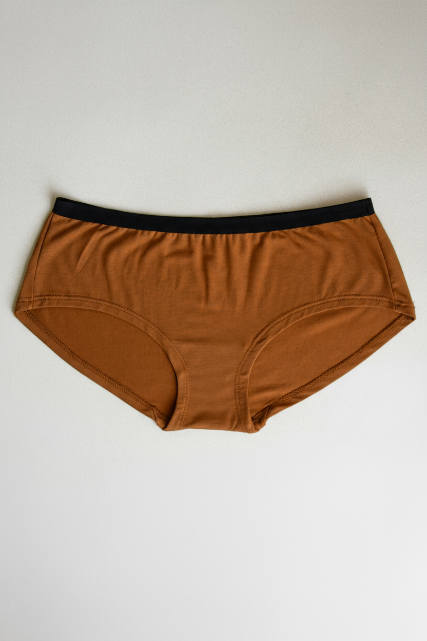 Orange underwear with black waistband on a light gray background