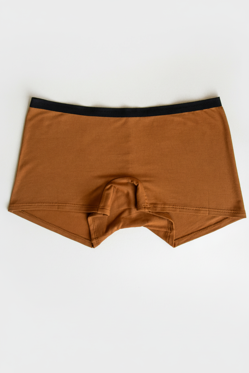 Orange women’s boxer underwear with a black waistband, flatlay on white background.