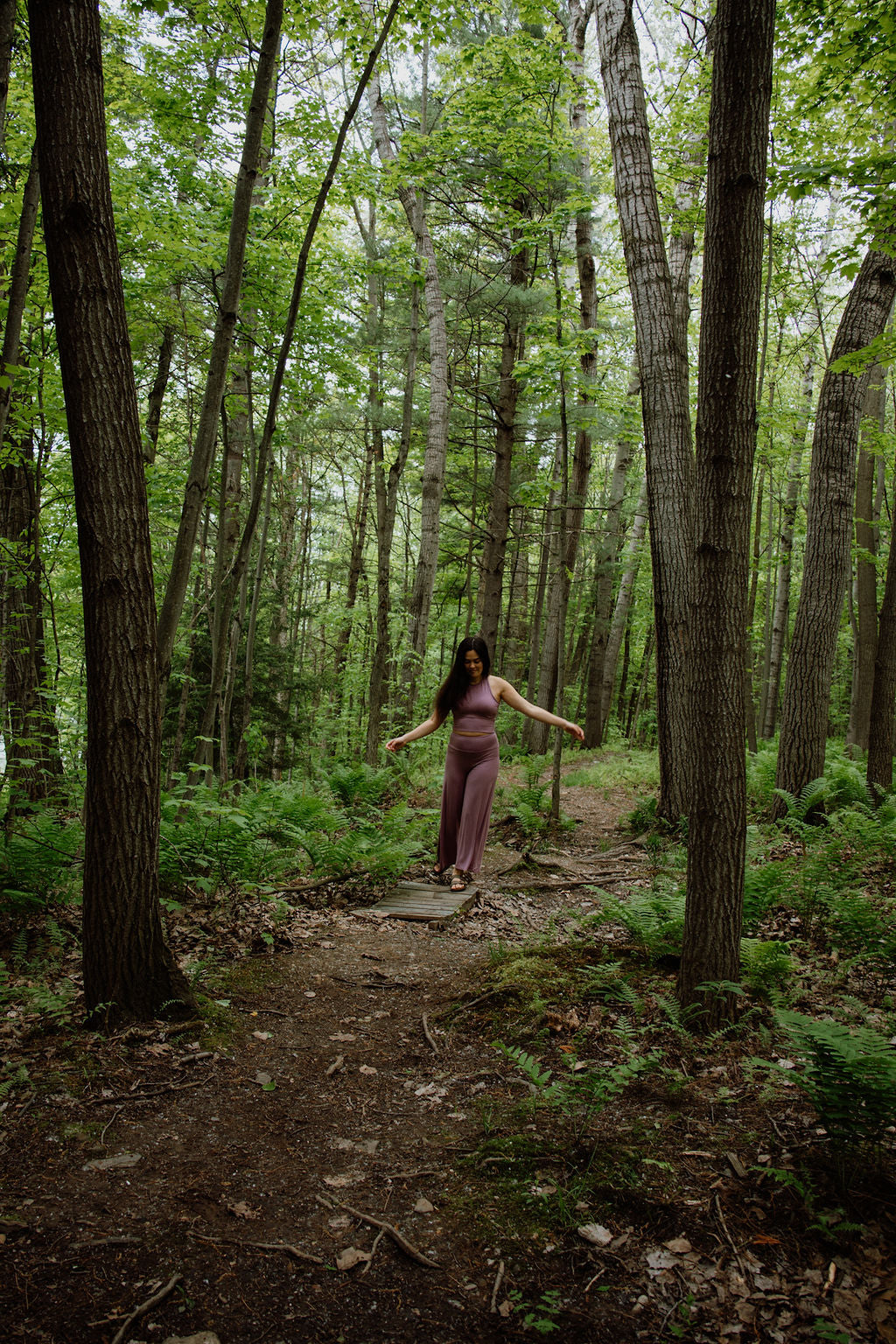 Woman walking on a path through a dense forest