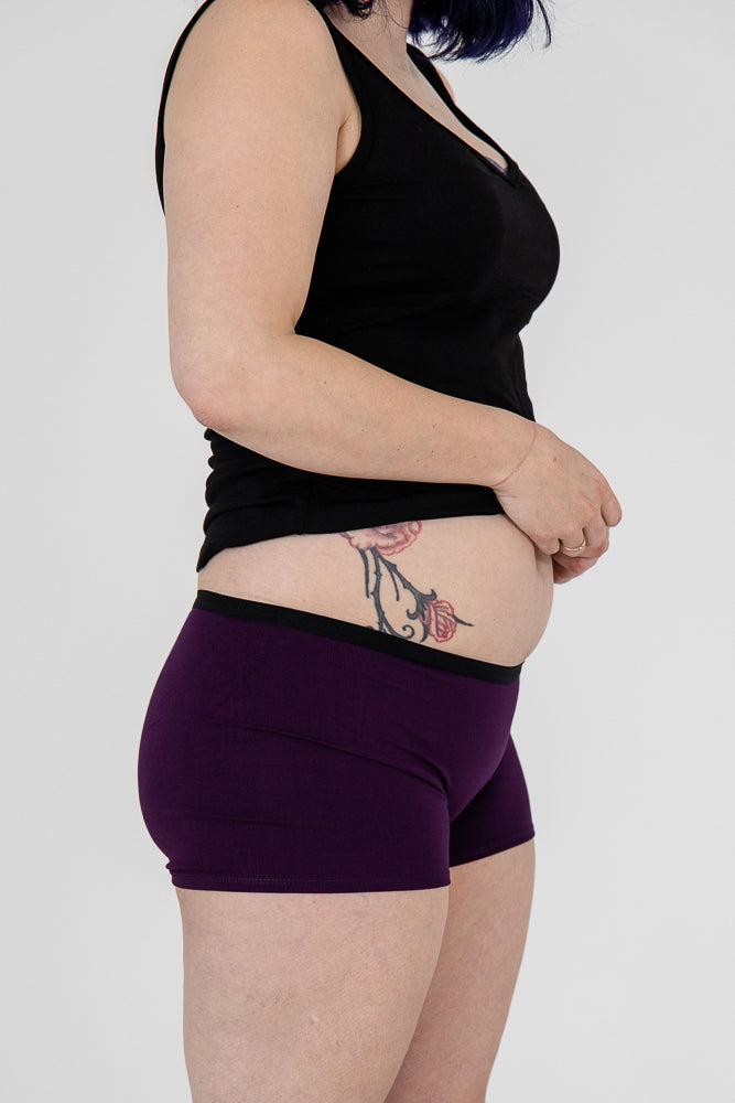 Woman wearing a soft grey bamboo boxer against a white background.
