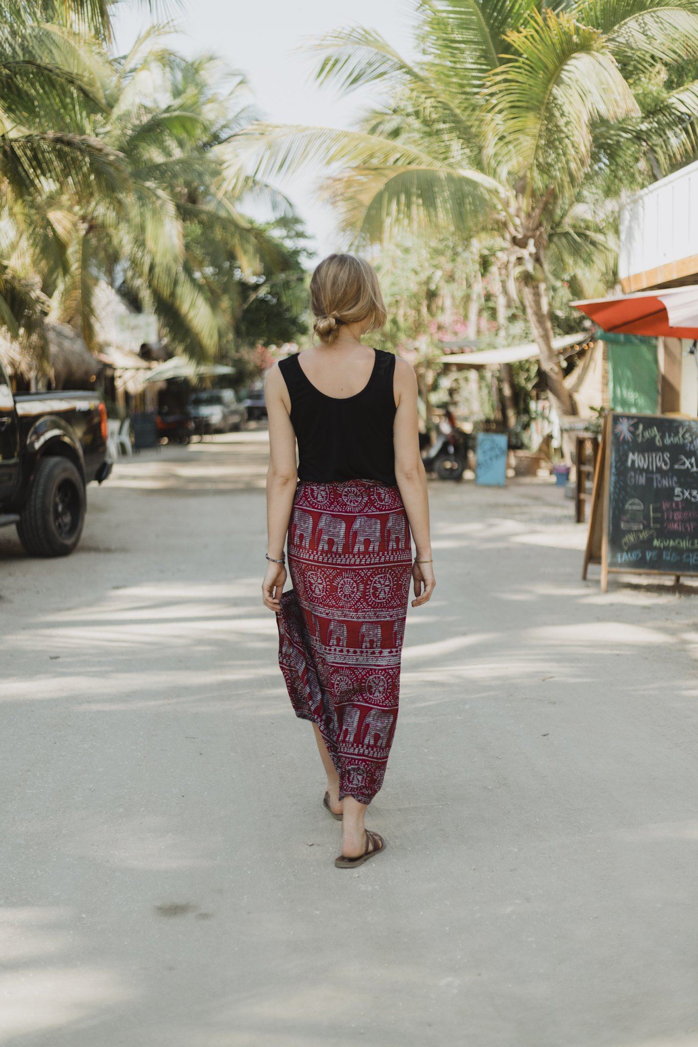 Back view of the black reversible bamboo camisole worn by a woman.