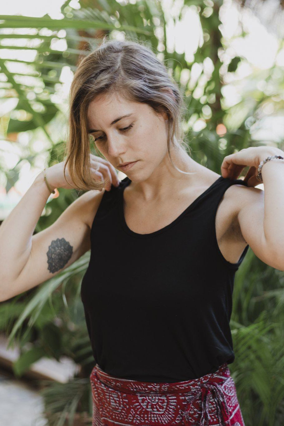 Close-up of a woman wearing the black reversible bamboo camisole, front view with scoopneck.