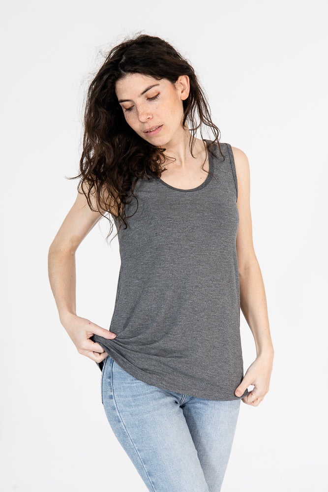 Woman wearing the grey reversible bamboo camisole, front view, with a pair of jeans.